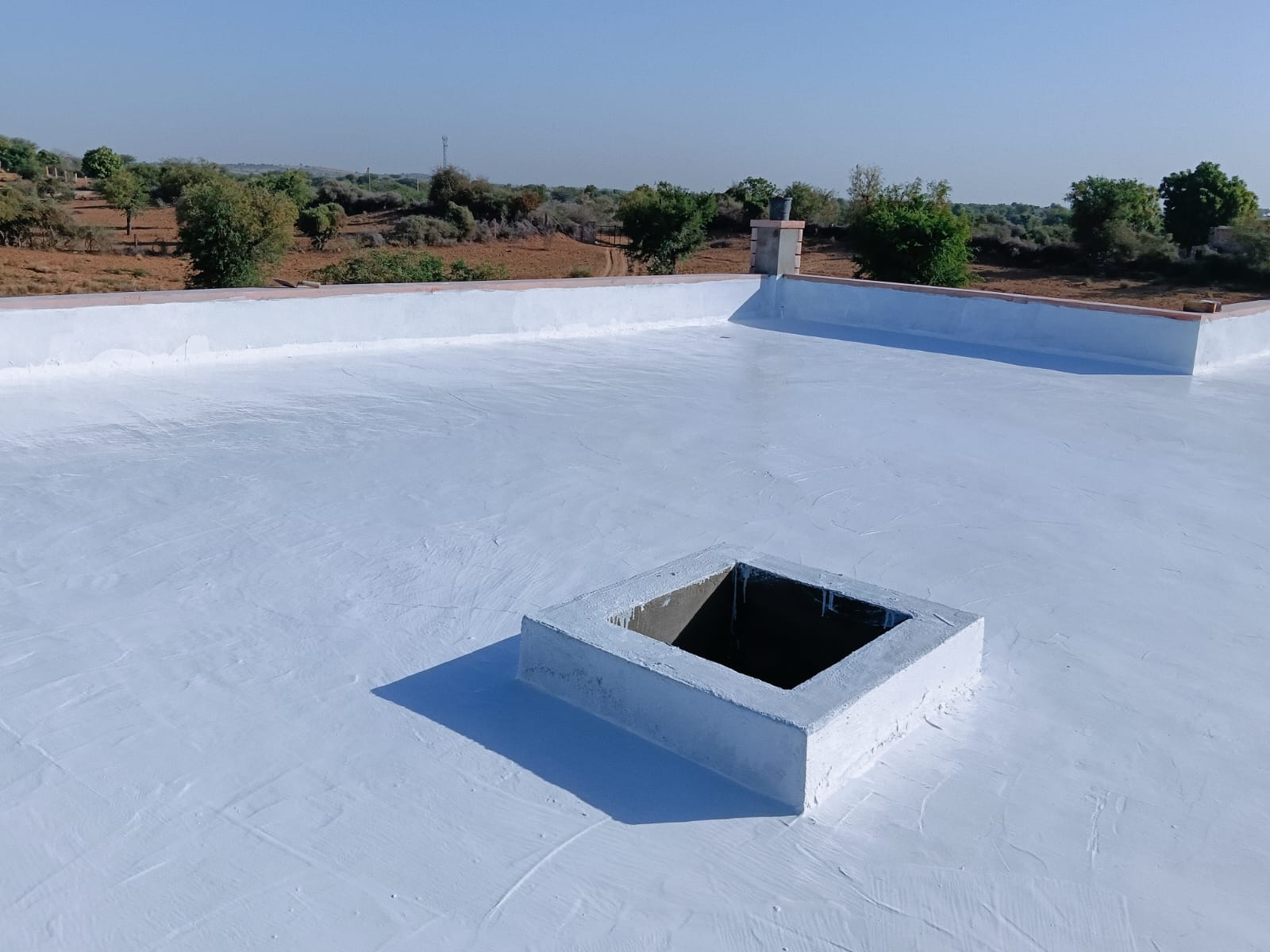 Wide view of finished waterproofed terrace with chimney and parapet walls